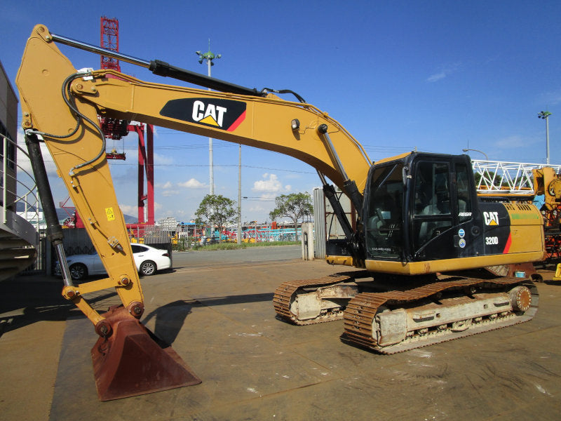 Yellow Caterpillar excavator on a construction site with a clear sky.