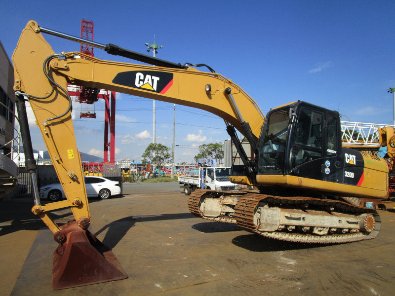 Yellow Caterpillar excavator on a construction site with a clear blue sky.