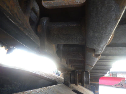 Close-up of a mechanical component, possibly part of a vehicle or machinery, with a blurred background.