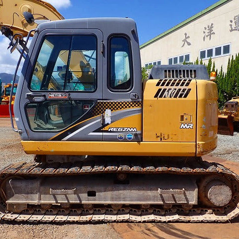 Yellow excavator with 'Norton' branding on a construction site.