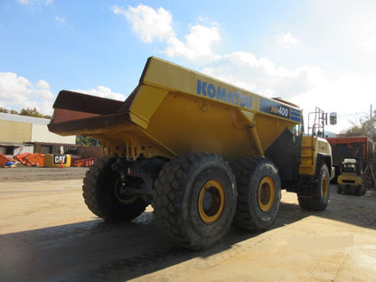 Yellow Komatsu dump truck on a construction site with a clear sky.