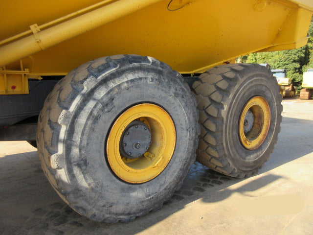 Close-up of large yellow wheels on a construction vehicle with a date stamp in the corner.