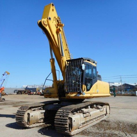 Yellow excavator on a construction site with a clear blue sky.