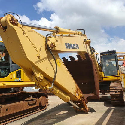 Yellow Komatsu excavator on a construction site with a blue sky.